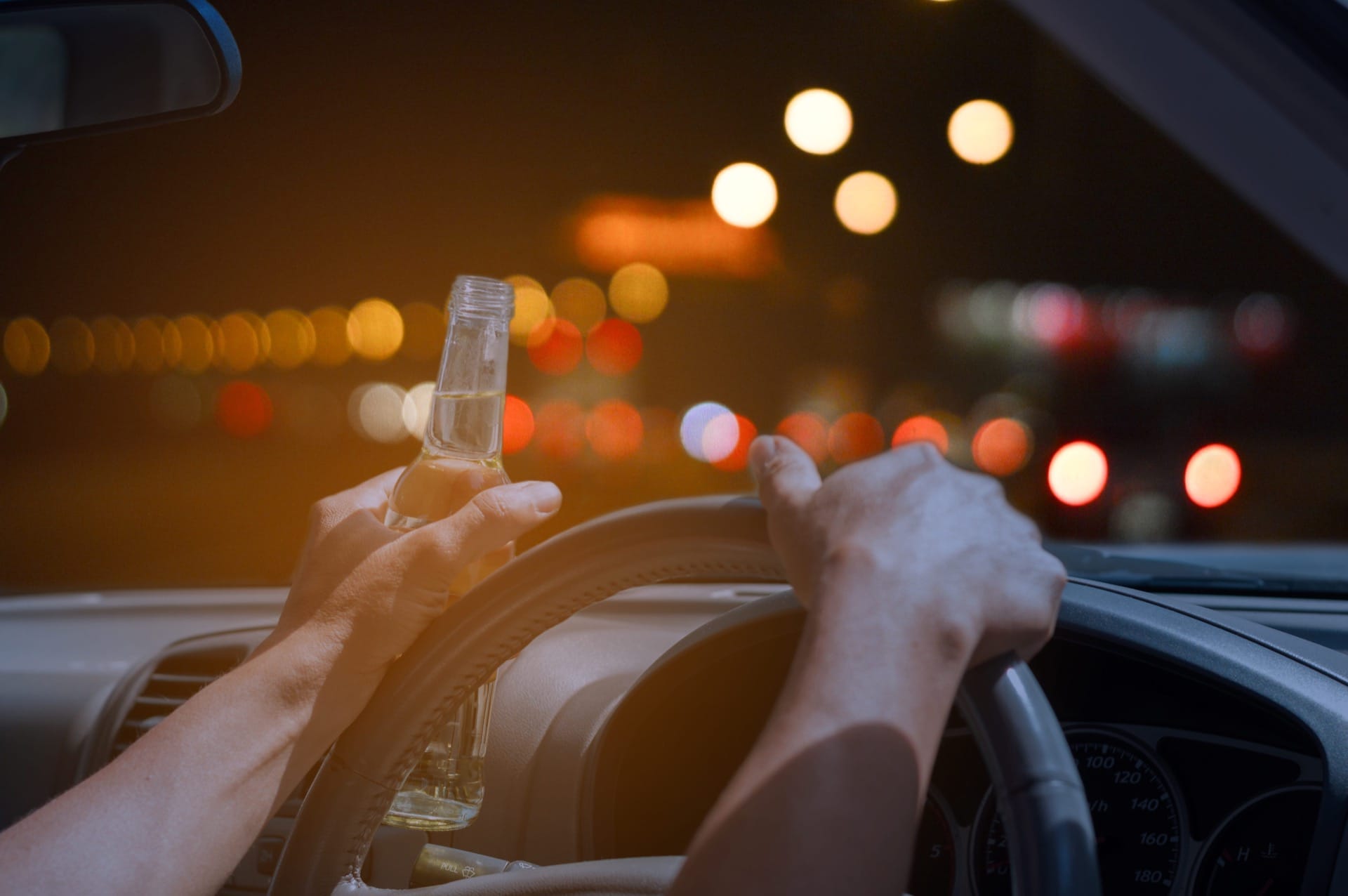 Person holding beer while driving